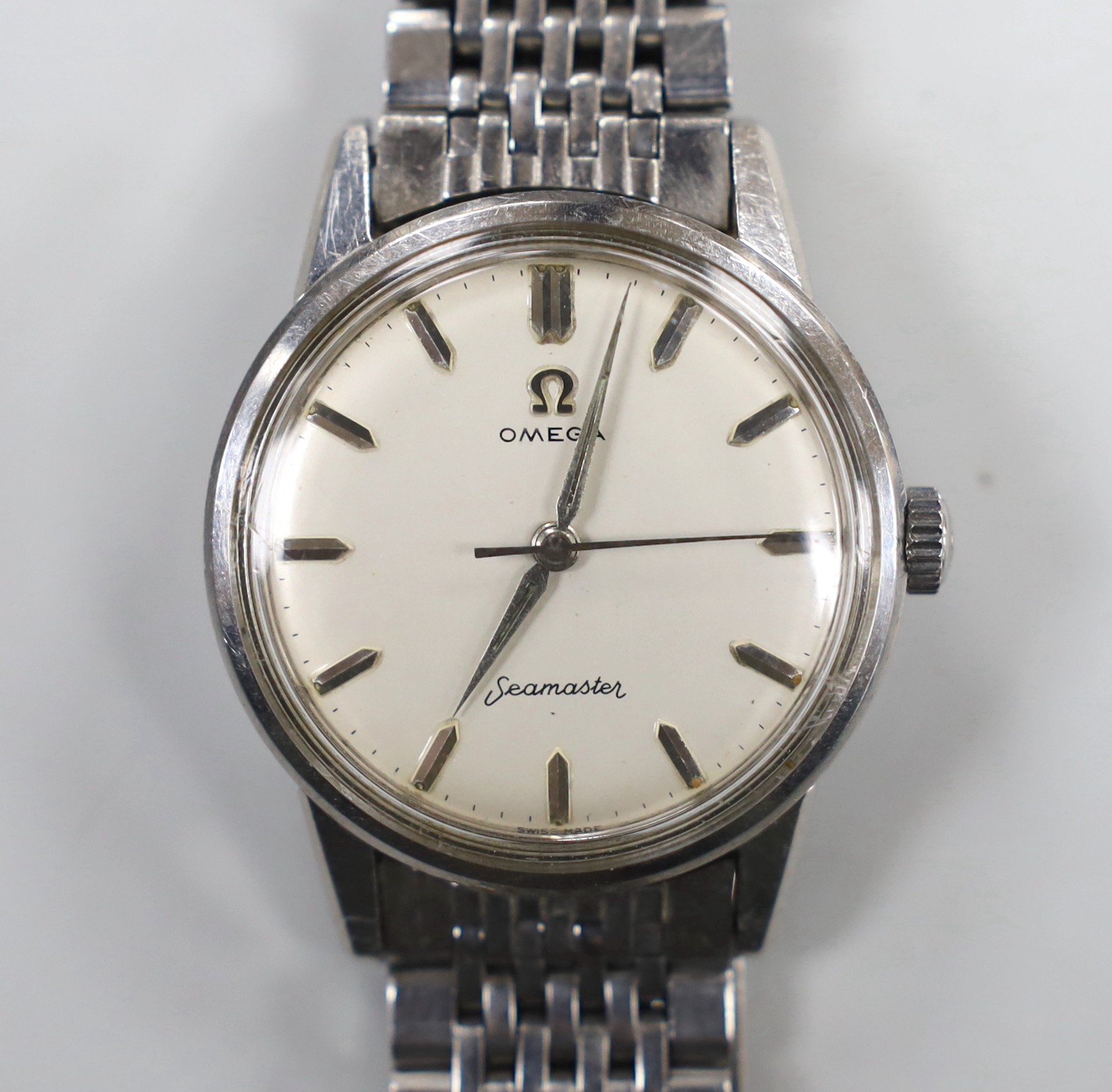 A gentleman's stainless steel Omega Seamaster manual wind wrist watch, on steel Omega bracelet, case diameter 35mm.
